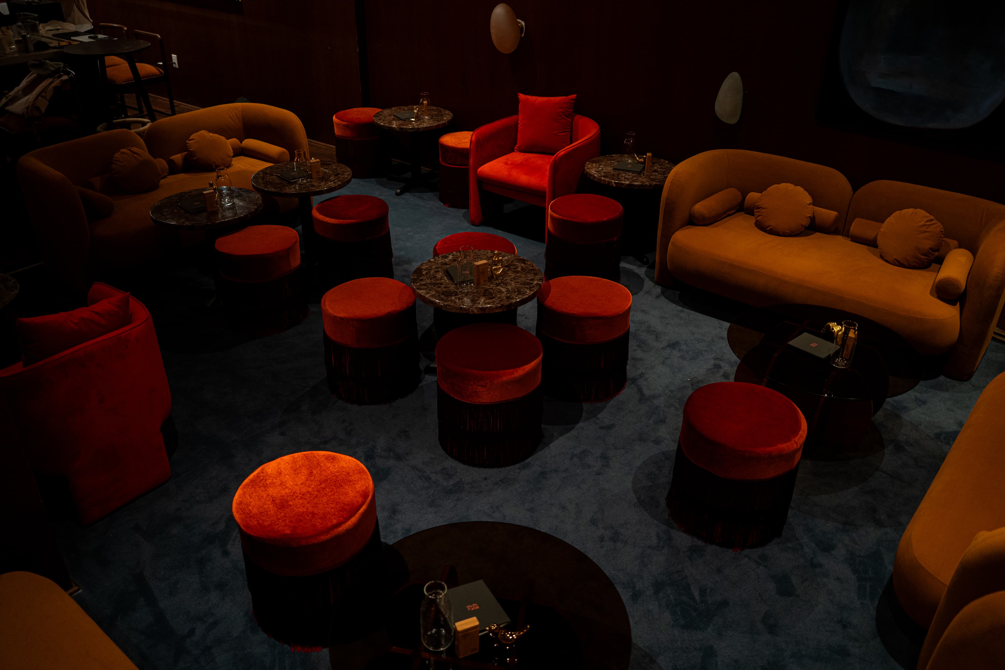 Top-down view of seating layout with red stools and blue carpet at RokuNana